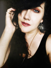 Load image into Gallery viewer, Woman with dark hair wearing gold eye earrings with a crystal quartz stone in the center